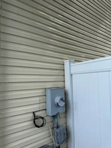 A clean white fence panel meeting the siding