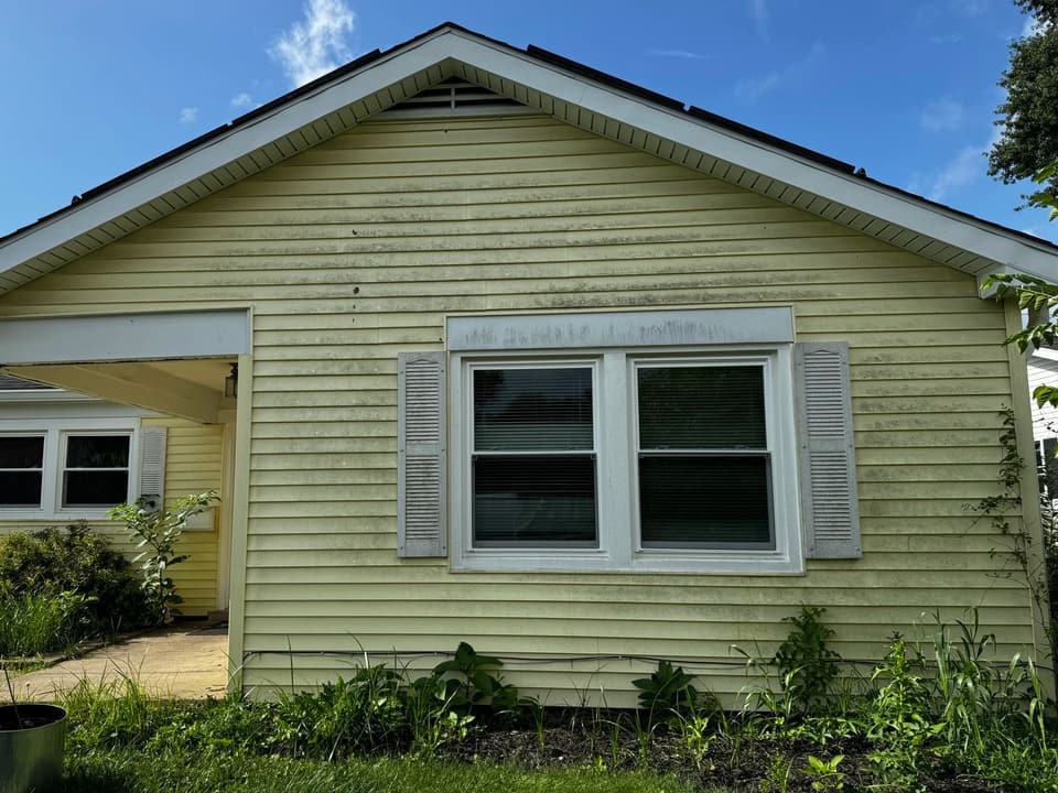 Before: yellow vinyl siding streaked with green algae and dirt